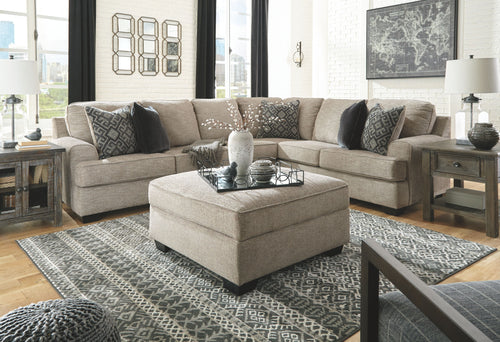 Beige sectional sofa set with center ottoman and patterned accent pillows