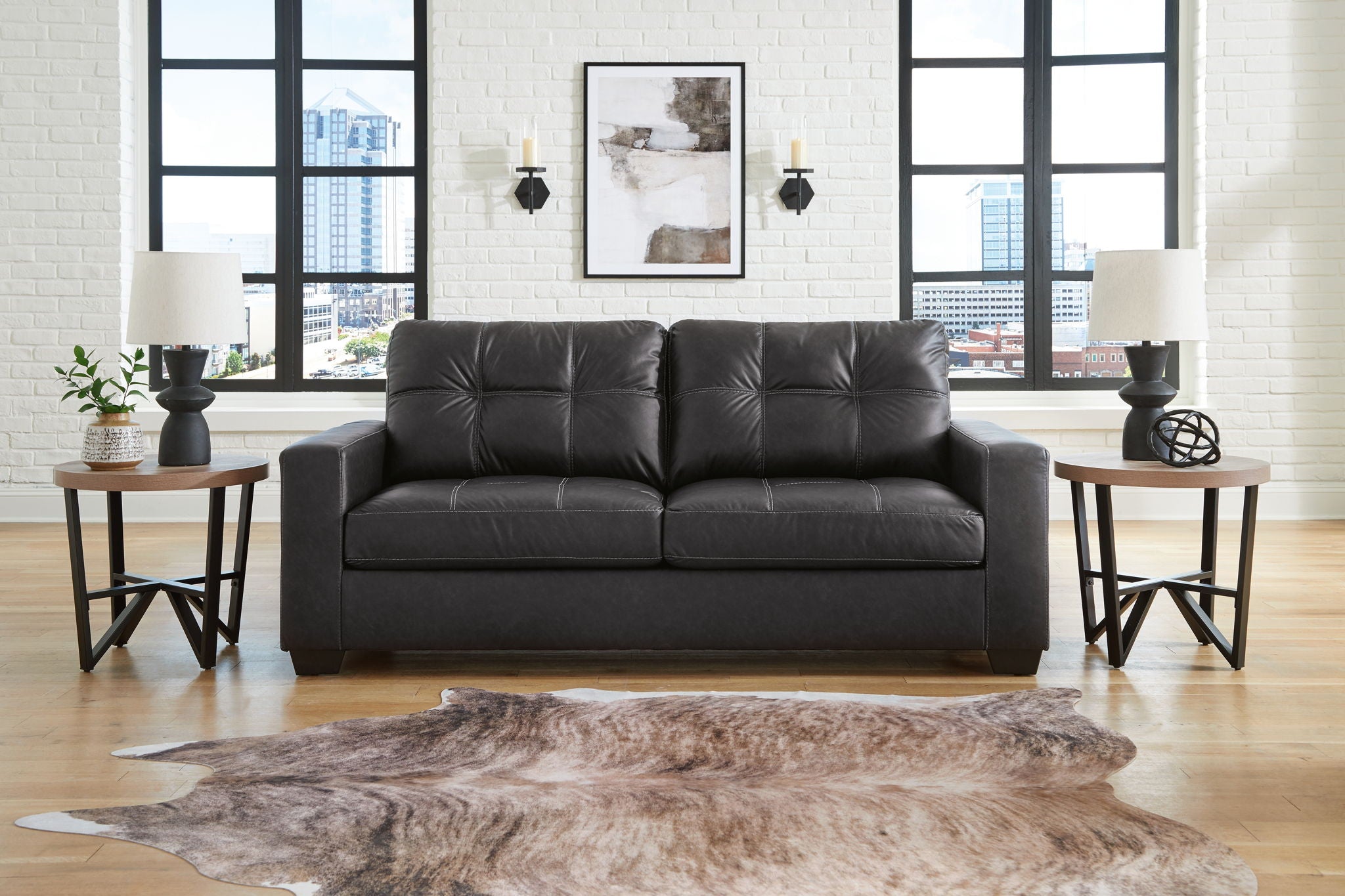 Dark leather-look loveseat with two seat cushions and tufted backrest, straight arms
