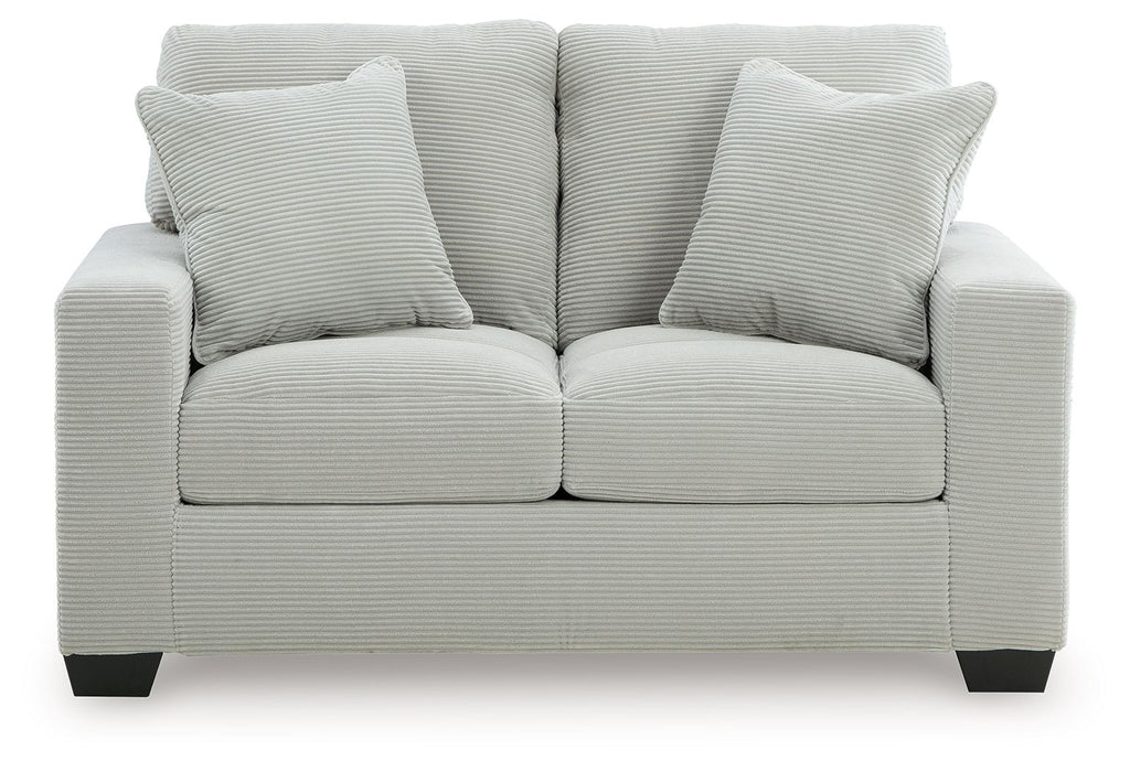 Upholstered loveseat with two seat cushions and three striped back pillows, light upholstery