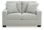 Upholstered loveseat with two seat cushions and three striped back pillows, light upholstery