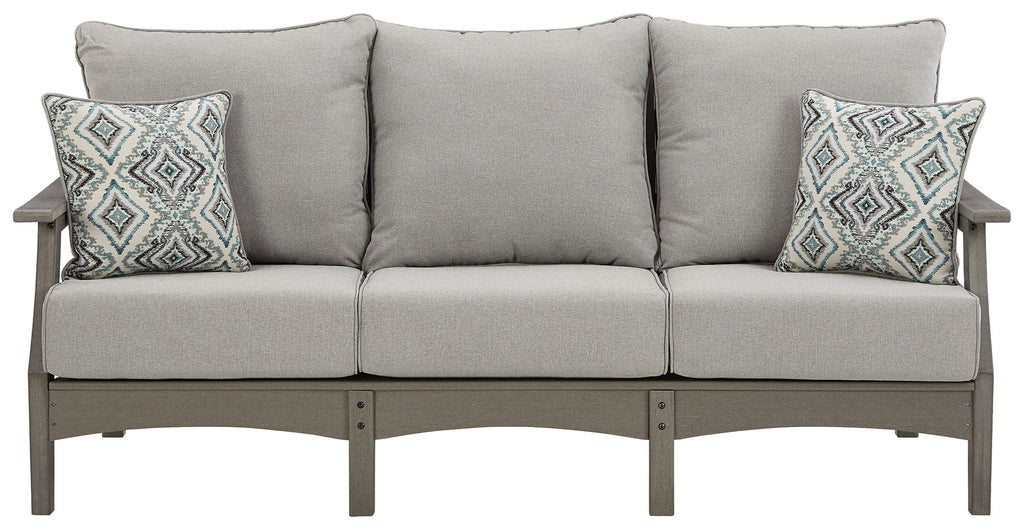 Gray outdoor sofa with three seat cushions and two geometric patterned back pillows