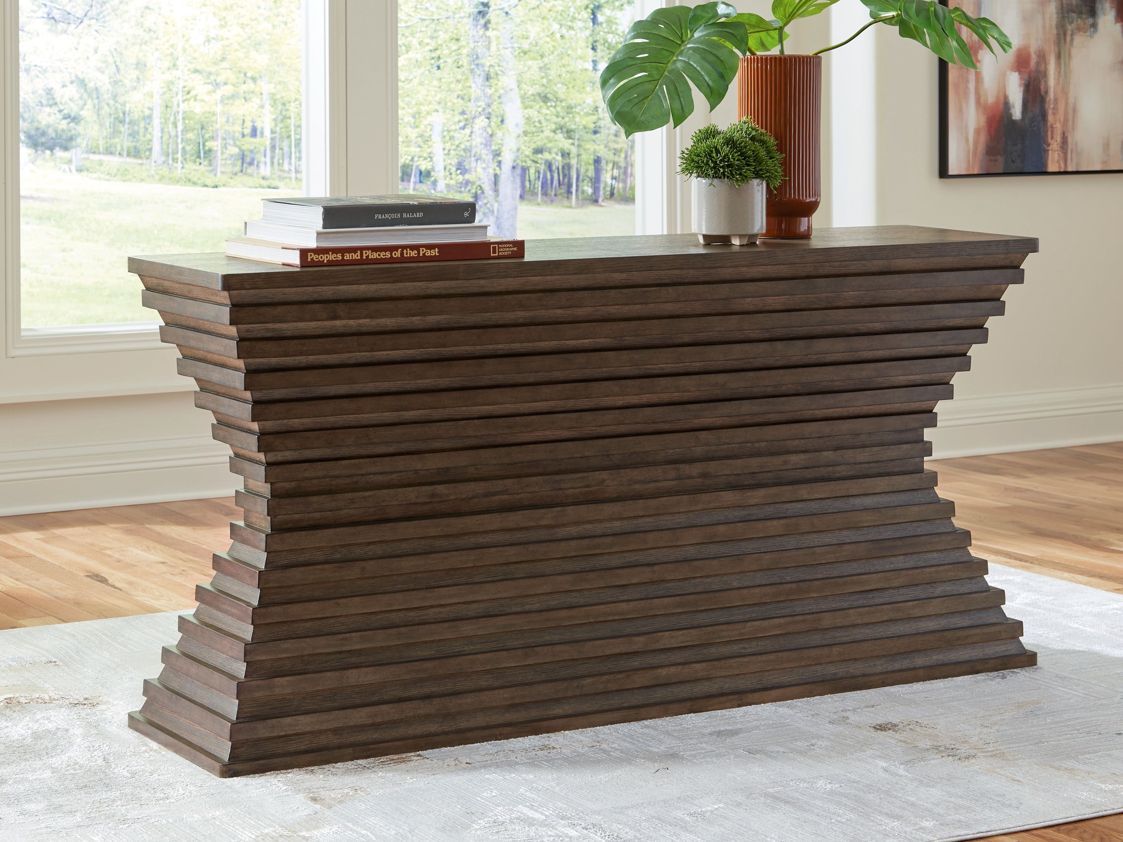 Warm brown sofa table with sculpted stacked sides and flat rectangular top