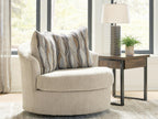 Beige swivel accent chair with upholstered arms and patterned pillows