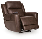 Dark brown power lift recliner in faux leather with extended footrest and stitched seams