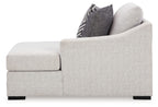 Light gray corner chaise with wide armrest and dark geometric throw pillow.
