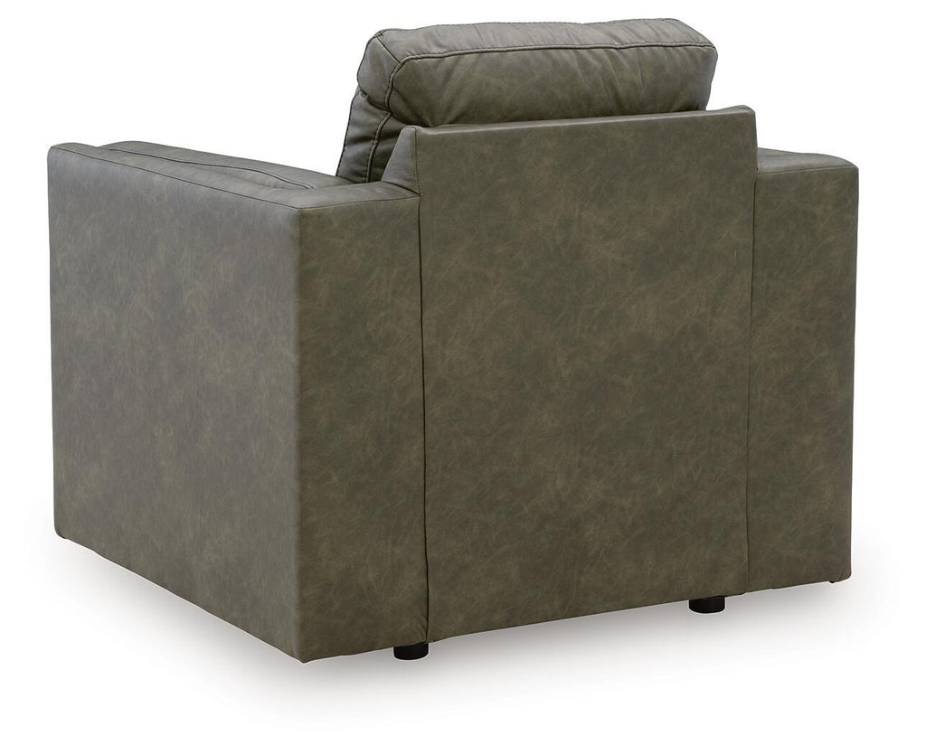 Olive green upholstered armchair facing away, with padded arms and square seat