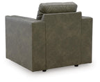 Olive green upholstered armchair facing away, with padded arms and square seat
