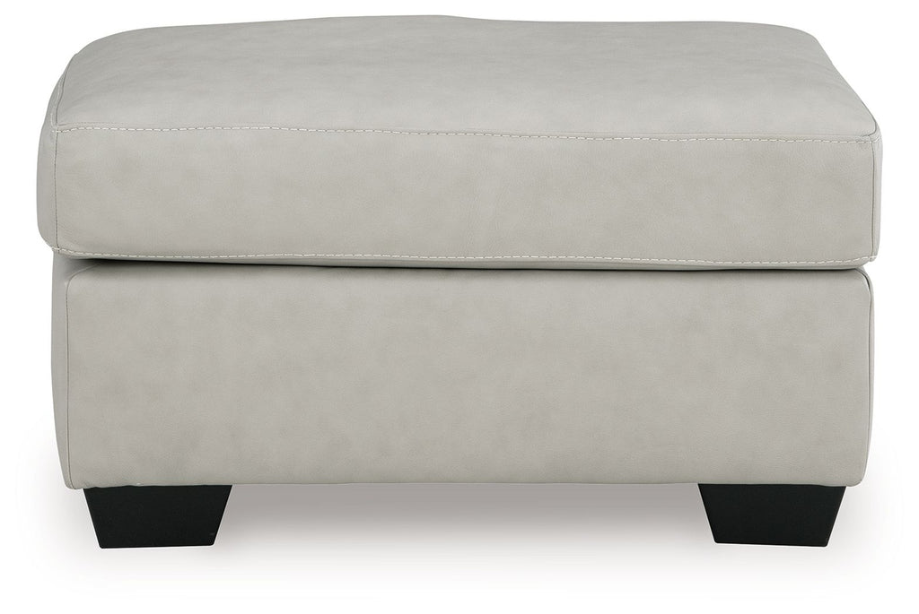 Light beige ottoman with padded top, smooth upholstery, and dark block legs