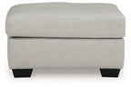 Light beige ottoman with padded top, smooth upholstery, and dark block legs