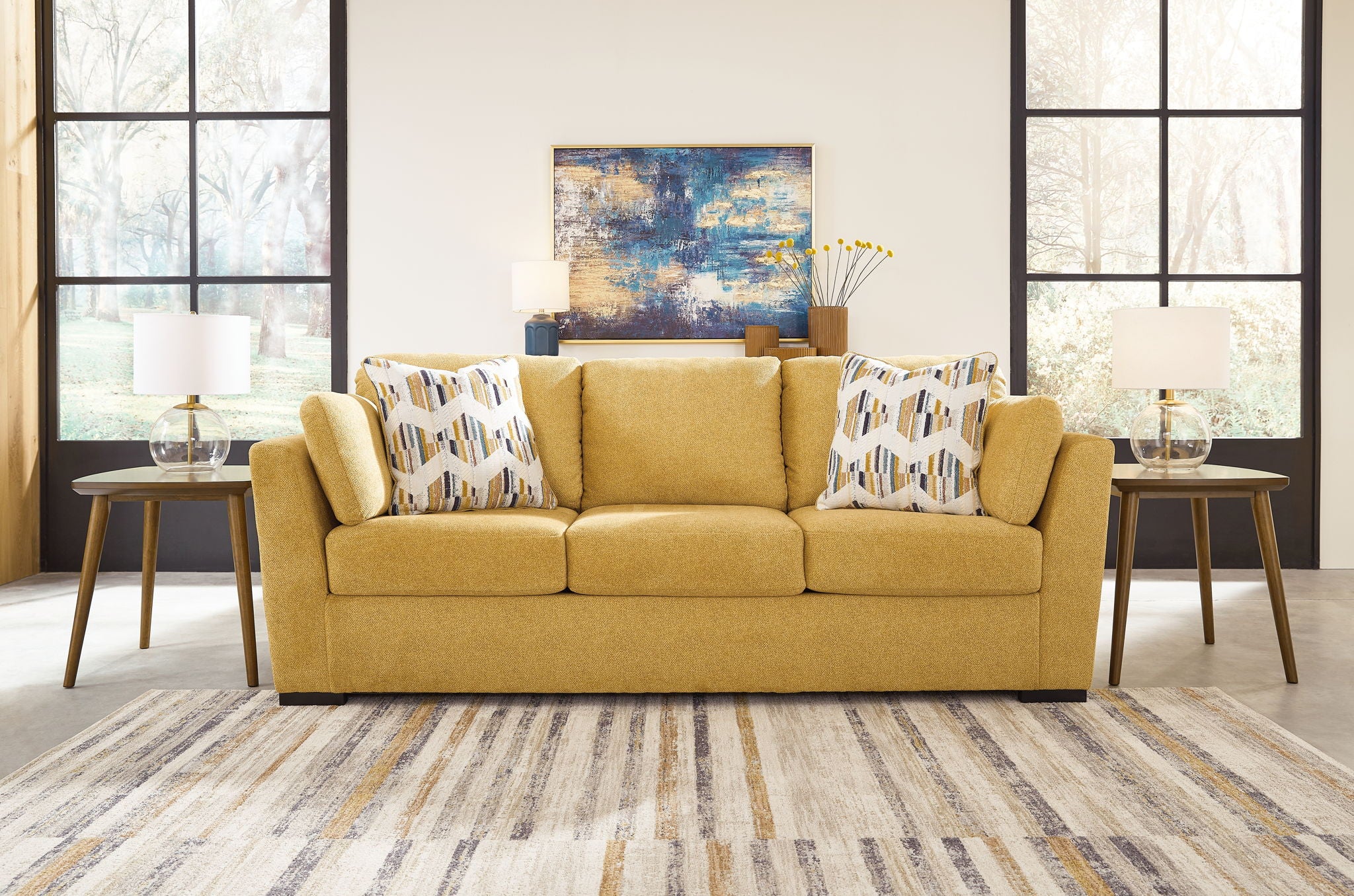 Yellow upholstered sofa with patterned throw pillows and cushioned seat back