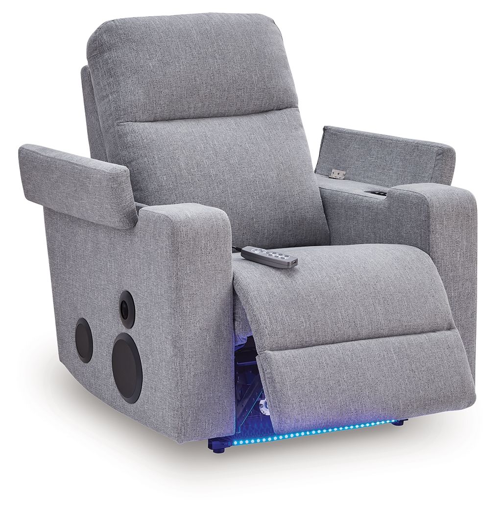 Pewter gray power recliner with speaker cutouts, remote on armrest, open footrest