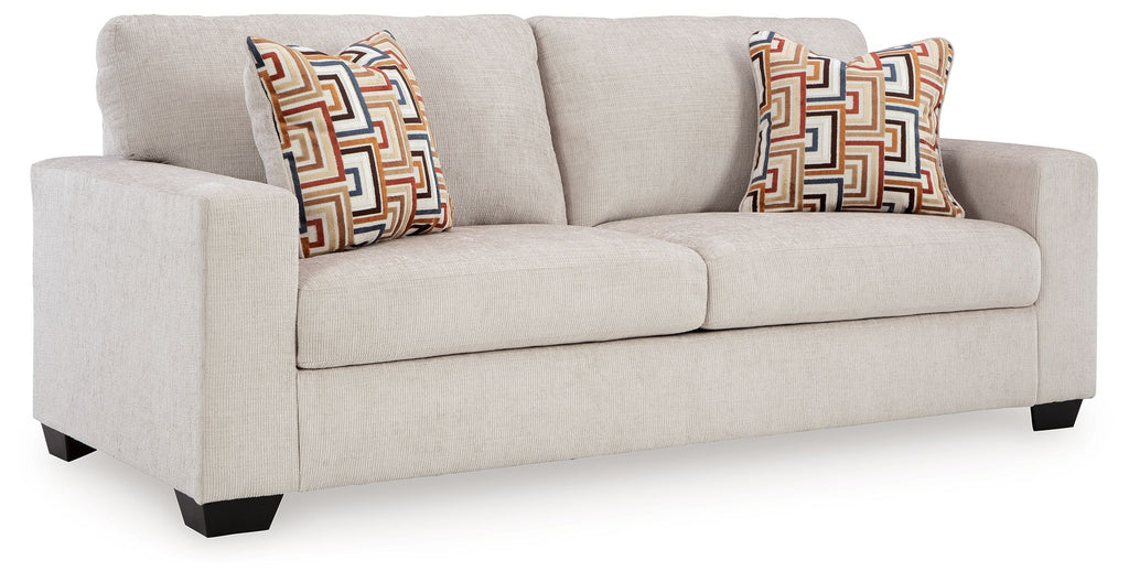Stone sofa sleeper with two patterned throw pillows, front three-quarter view.