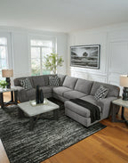Gray sectional sofa with chaise and patterned pillows, wide seat cushions