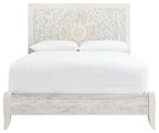 Whitewash queen panel headboard with ornate white fabric backing and upholstered bed