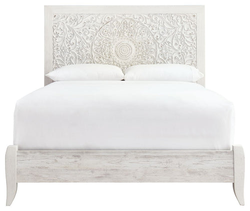 Whitewash queen panel headboard with ornate white fabric backing and upholstered bed