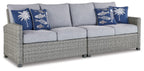 Light gray 3-seat outdoor sofa with blue patterned throw pillows