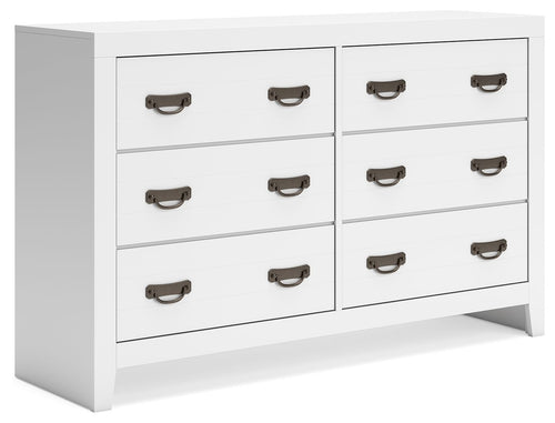 White dresser with multiple drawers and dark metal pull handles