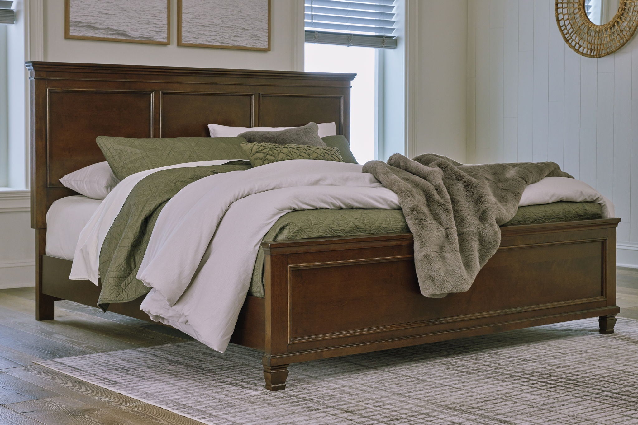 Dark brown panel bed with white linens and two storage drawers, green throws on top.