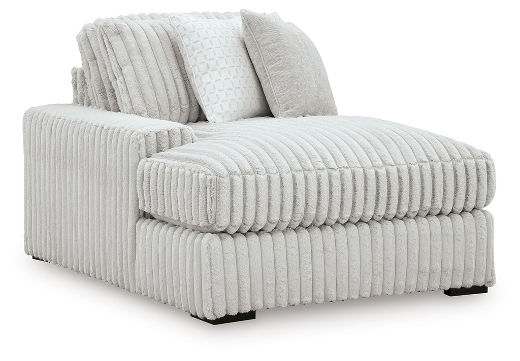 White ribbed corner chaise with plush bolster pillows and chaise seat extension