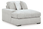 White ribbed corner chaise with plush bolster pillows and chaise seat extension