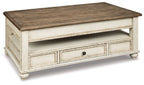 Lift-top cocktail table, dark wood top, white base with drawer and paneled doors.