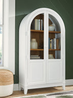 White accent cabinet with arched glass doors and interior shelving with decor