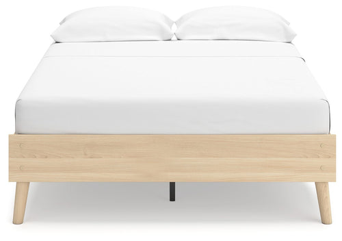 Platform bed with white upholstered mattress and light wood platform base, dark feet
