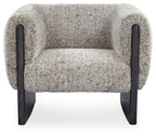 Accent chair with oatmeal boucle seat and back, dark wood legs, and padded side arms.
