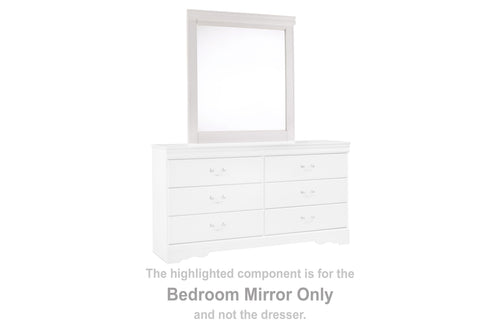 White rectangular bedroom mirror on top of a dresser with six drawer fronts