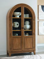 Light brown arched accent cabinet with double doors and glass panels, visible shelves