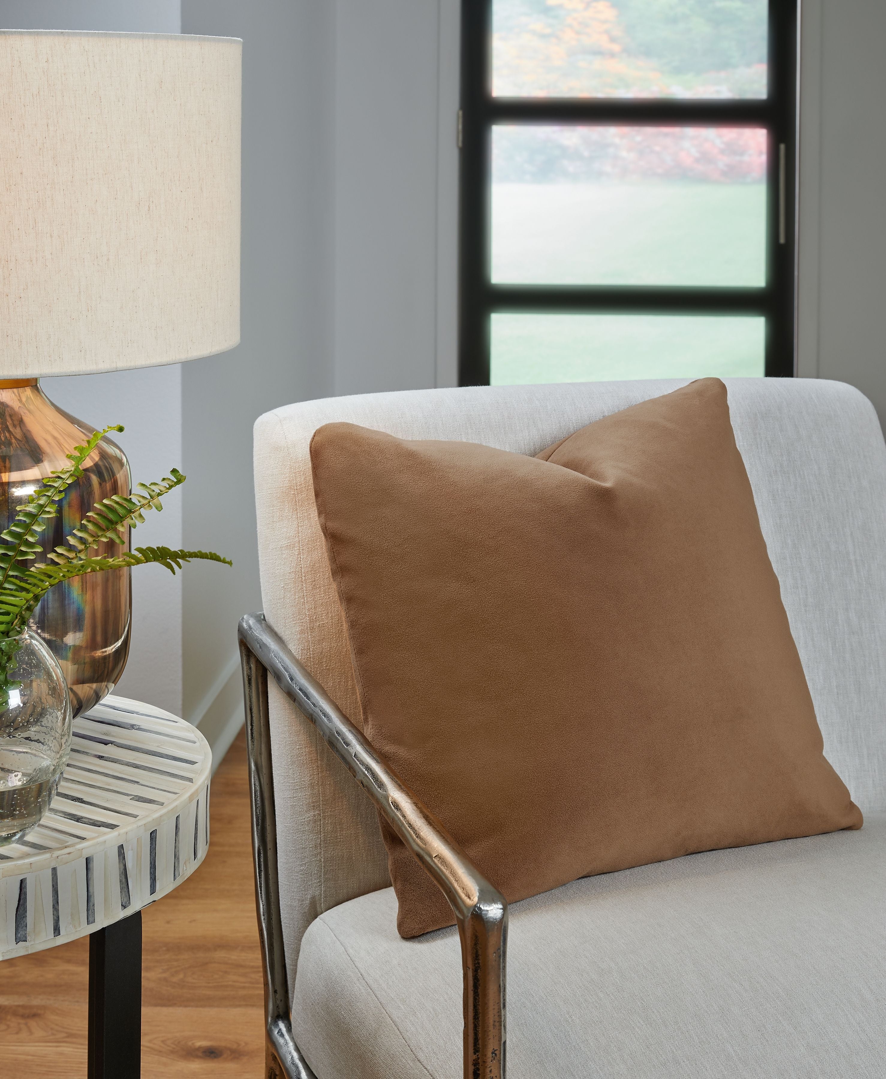Light brown square throw pillow on upholstered chair