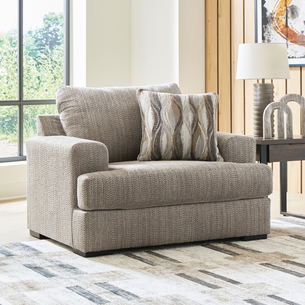 Gray chair and a half with tall back, wide seat, and patterned cushion