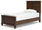 Dark brown panel bed with storage drawer fronts and white upholstered mattress