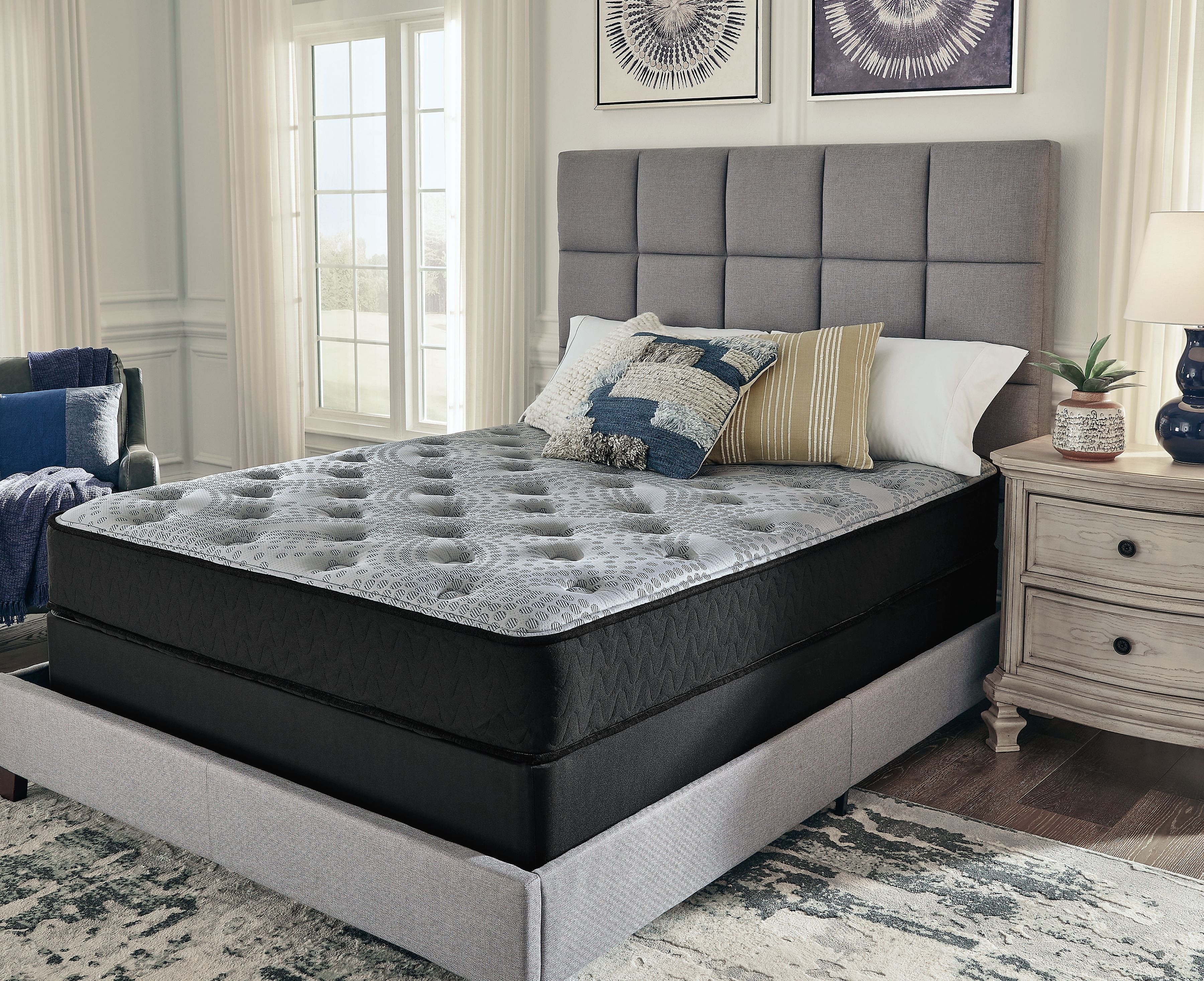 Hybrid mattress with gray quilted top on dark platform base