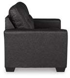 Black loveseat side view with tufted backrest and wide padded seat