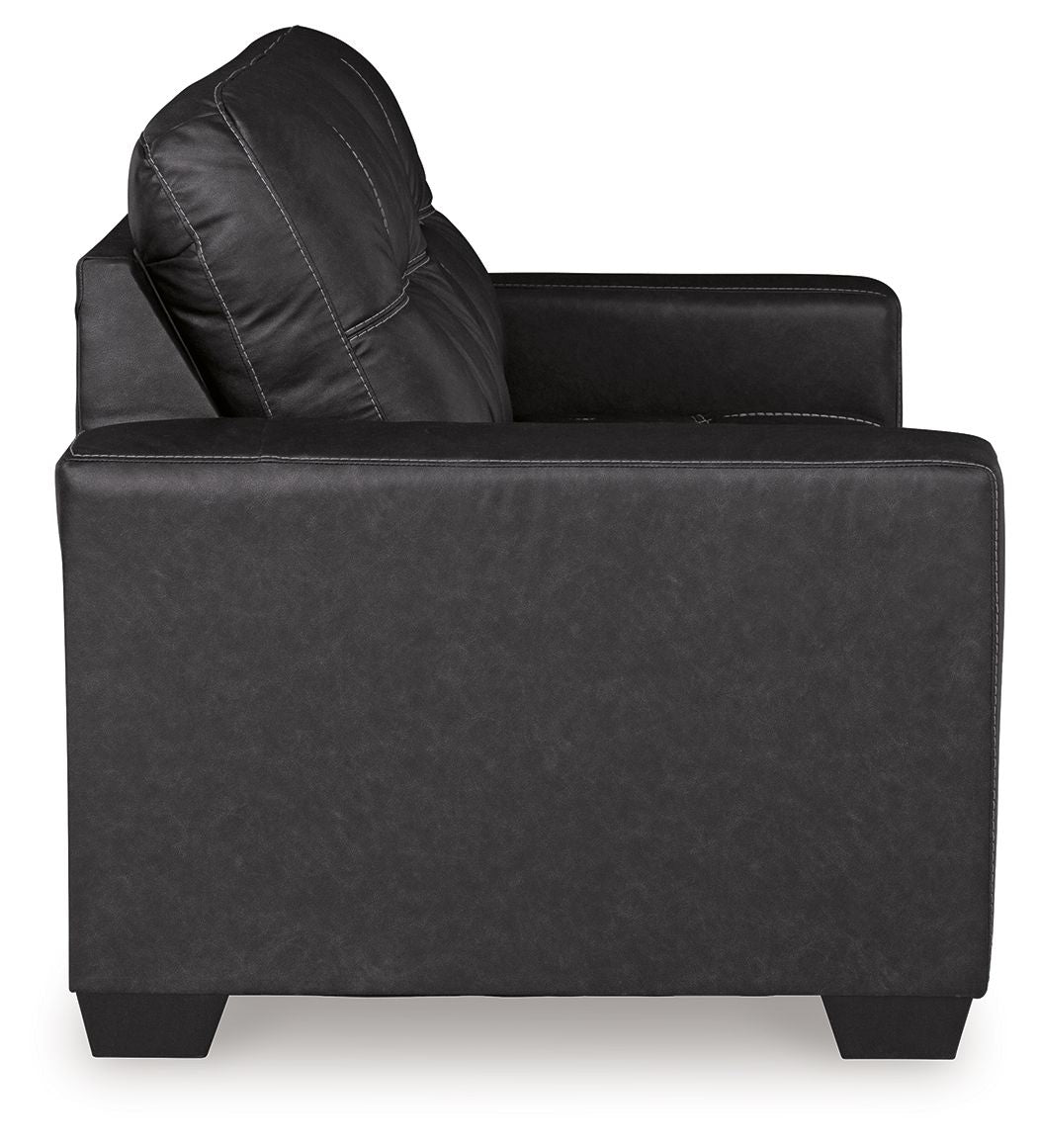Black loveseat side view with tufted backrest and wide padded seat