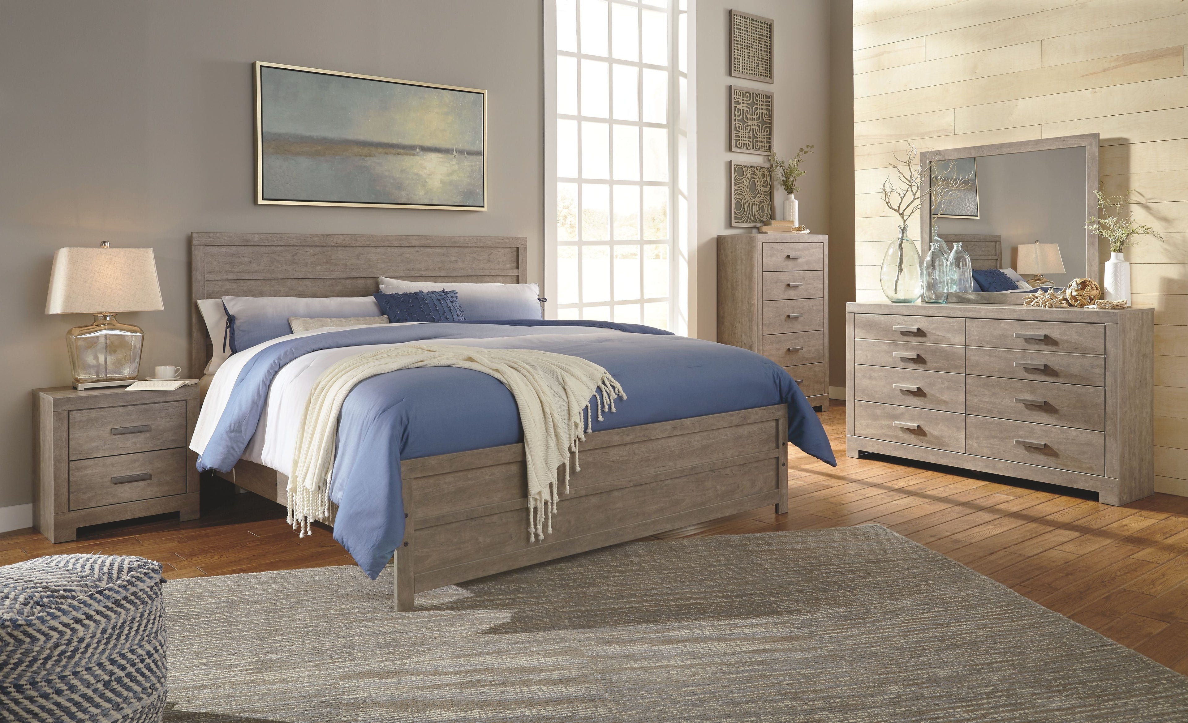 Gray dresser with mirror top and six drawers, finished with metal bar pulls