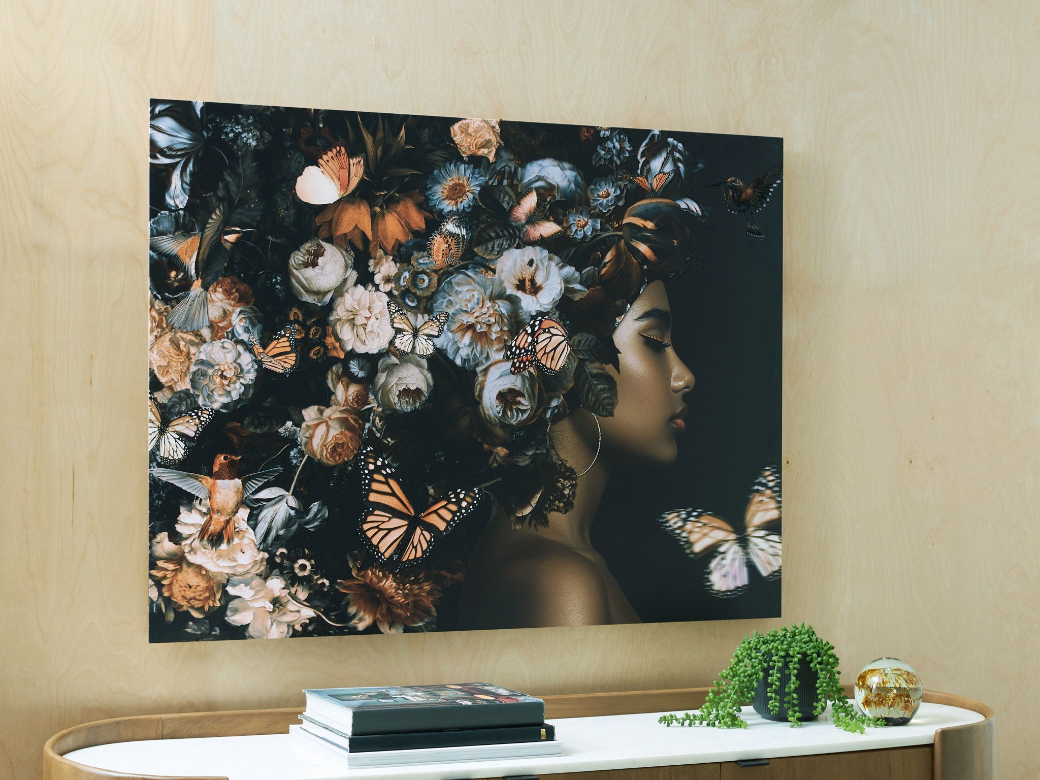 Floral wall art featuring a woman profile and butterflies in orange, black, and white