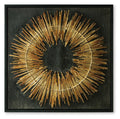 Black and gold circular wall art with metal stick sunburst in a square frame