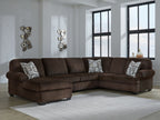 Chocolate sectional sofa with chaise seats and patterned throw pillows in a living room