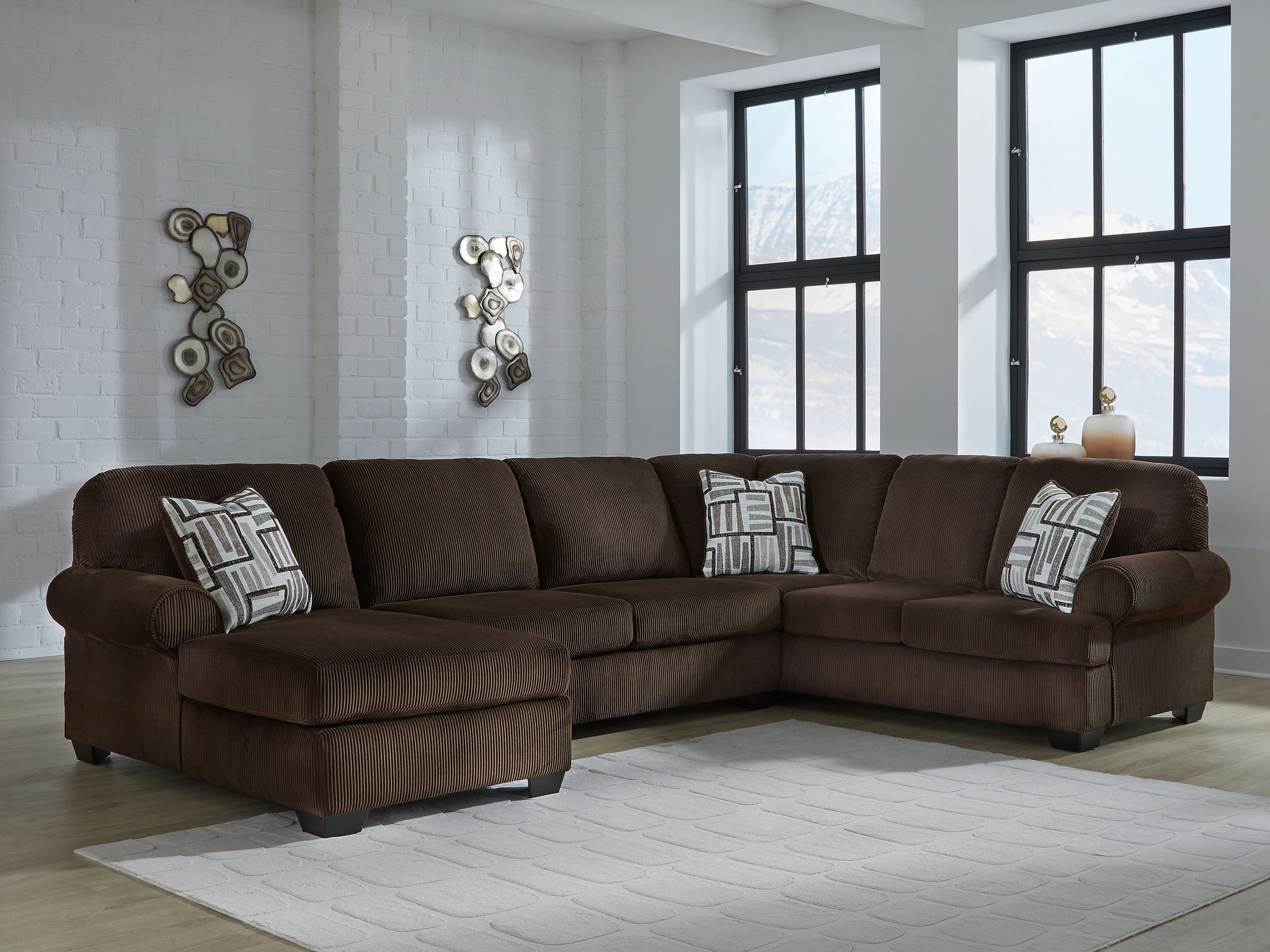 Chocolate sectional sofa with chaise seats and patterned throw pillows in a living room