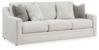 Chalk-colored sofa with three seat cushions and gray accent pillows
