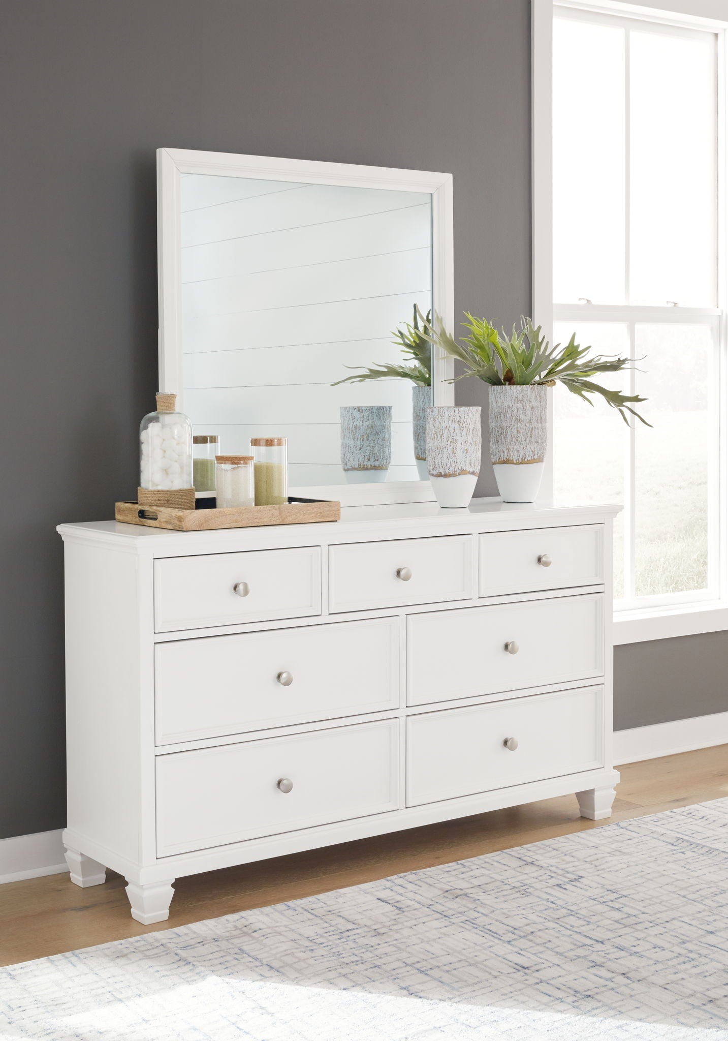 White dresser with multiple drawers and round metal knobs