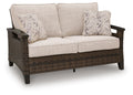 Monterey Point loveseat with cushion: dark brown woven frame, beige cushions, 2 patterned pillows