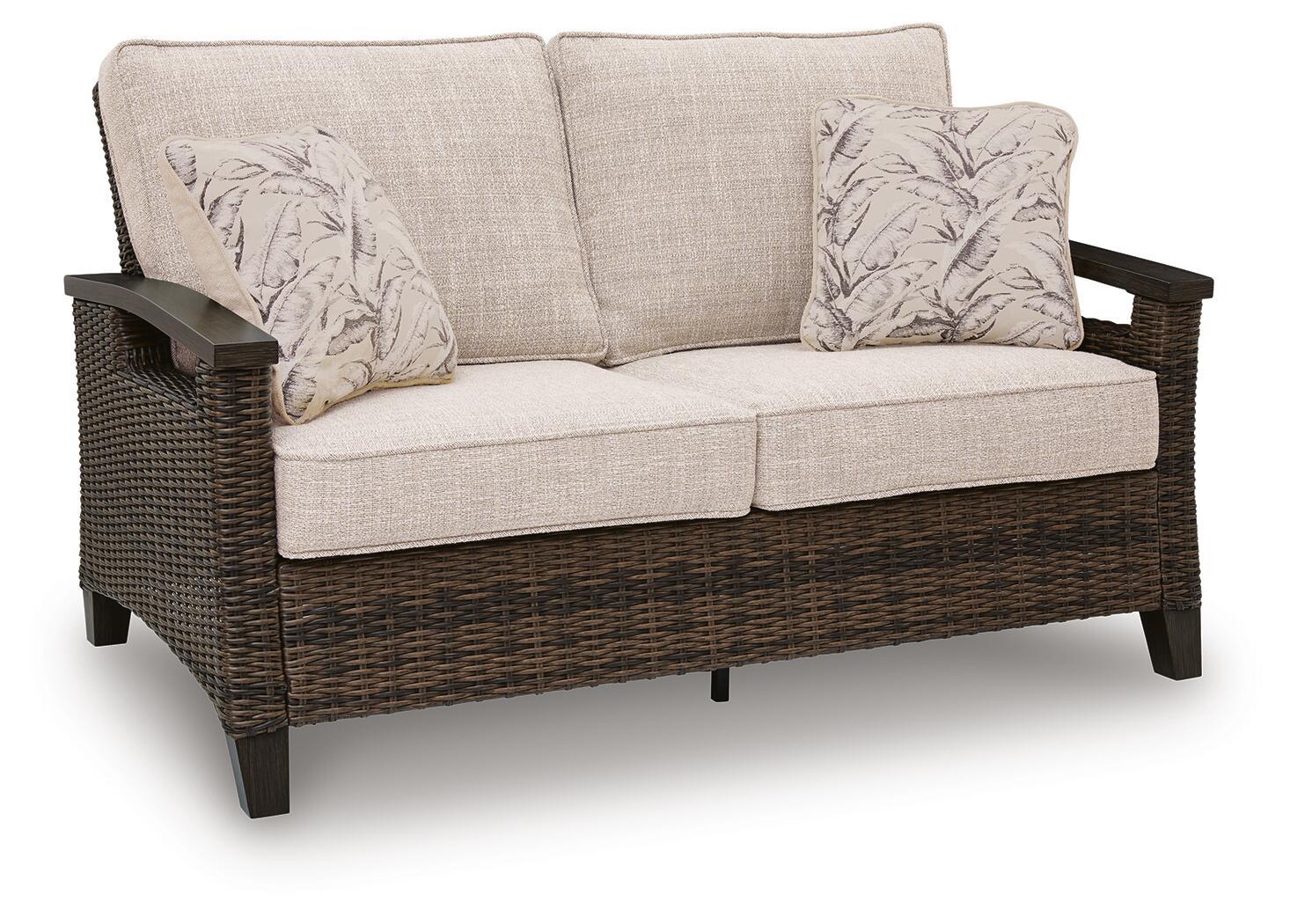 Monterey Point loveseat with cushion: dark brown woven frame, beige cushions, 2 patterned pillows