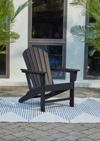 Outdoor Adirondack chair in dark blue with slatted back, armrests, and side supports.