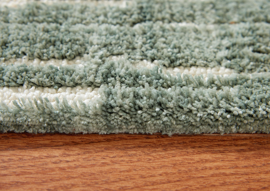 Light blue shag area rug with dense textured pile, close-up edge view