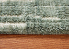 Light blue shag area rug with dense textured pile, close-up edge view