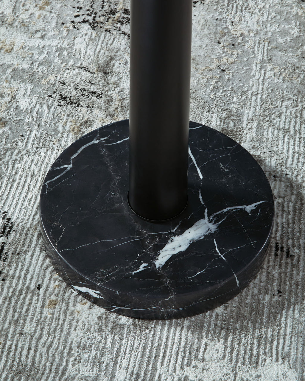 Marble-look black round base with central black pole for a gold floor lamp