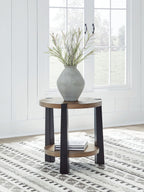 Round two-tier end table with light wood top and dark legs, placed in a living room.